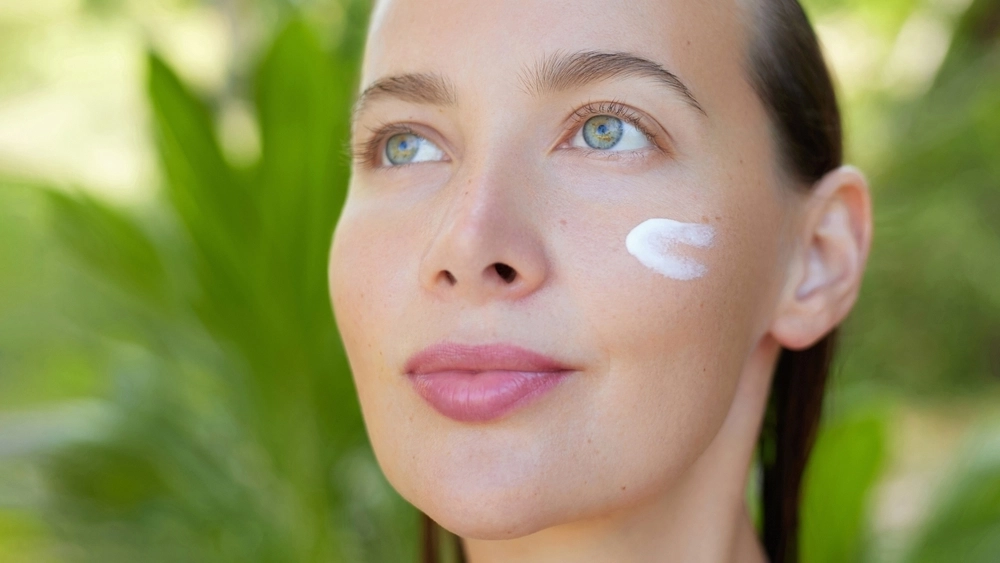 A woman with a small amount of white cream on her cheek