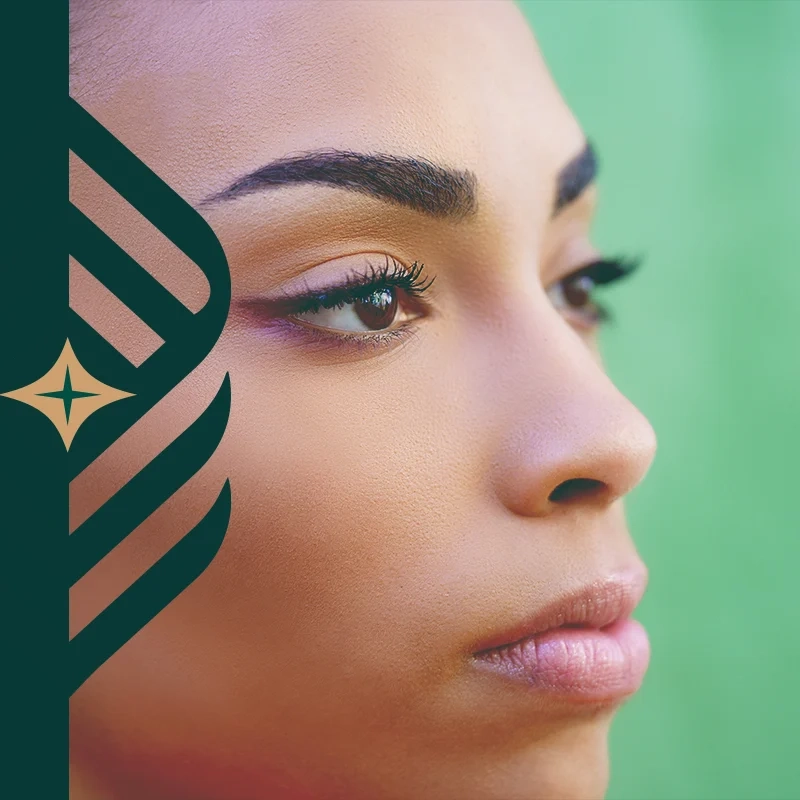 A woman with clear skin photographed in close-up against a green background