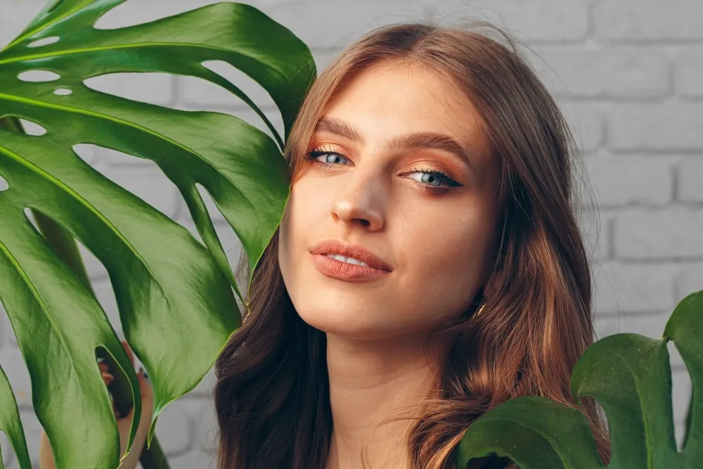 A woman with smooth skin among green leaves