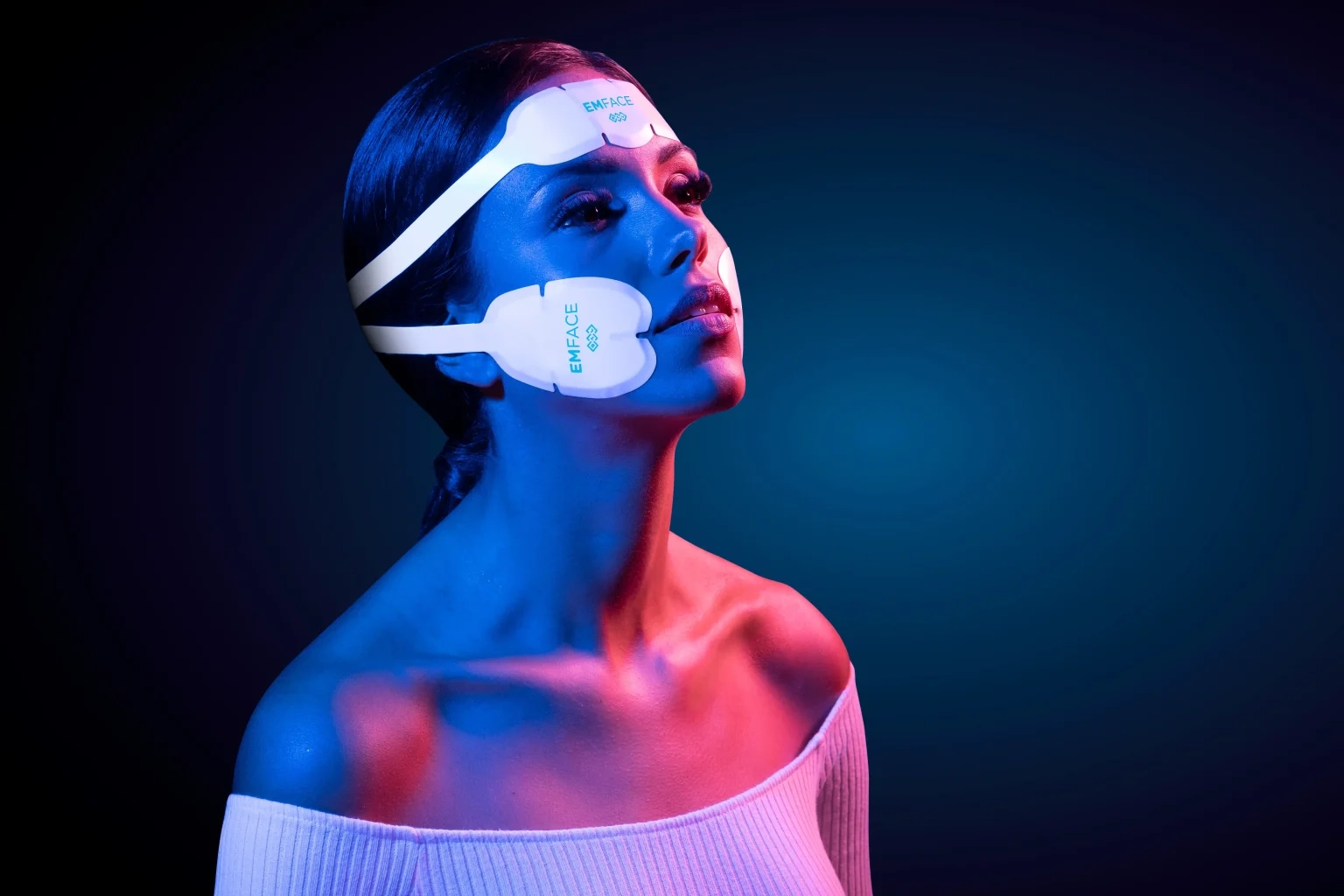 A woman wearing the Emface applicators on her forehead and cheeks